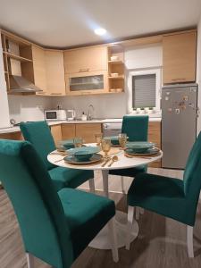 cocina con mesa y sillas verdes en Apartment GORA, en Međugorje
