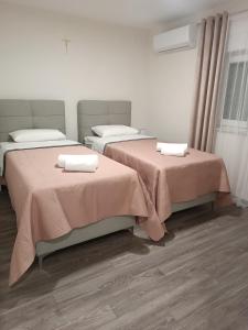 dos camas sentadas una al lado de la otra en una habitación en Apartment GORA, en Međugorje