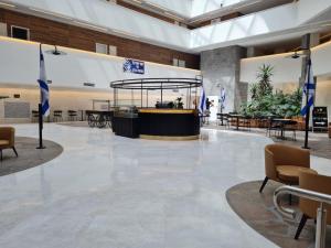 a lobby with tables and chairs and plants at Sea side 87 Sweet Me Eilat אילת in Eilat +17 photos