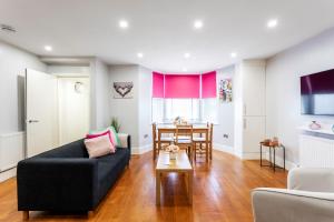 a living room with a couch and a table at Spacious Clapham Junction Apartment in London