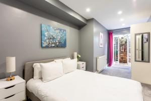 a bedroom with a white bed and a window at Spacious Clapham Junction Apartment in London