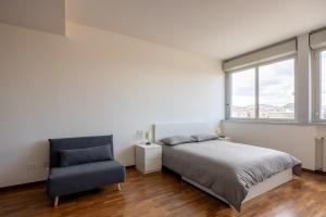 um quarto com uma cama e uma cadeira em Paolo Fabbri Apartment em Bolonha