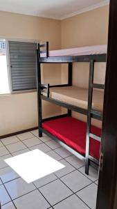 Pokój z 2 łóżkami piętrowymi i czerwoną poduszką w obiekcie Casa de Veraneio w mieście Laguna