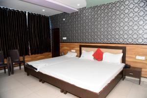 瓜廖爾的住宿－TRPOTEL SUBMANGAL，一间卧室配有带白色床单和红色枕头的床。