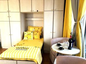 a bedroom with a bed and a table with a yellow blanket at Chambre Arena Porte La Chapelle in Paris