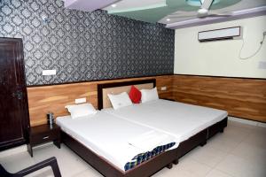 - une chambre avec un lit et une chaise dans l'établissement TRPOTEL SUBMANGAL, à Gwalior