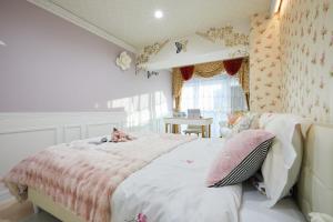 a bedroom with a bed with pink and white sheets at Papillon Paradis Higashi-Shinjuku in Tokyo