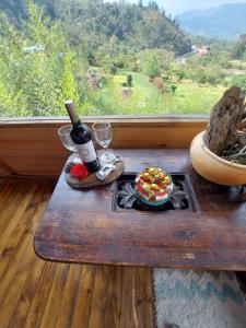 a table with a bottle of wine and a plate of food at Refugio Naturaleza en Armonia in San Francisco