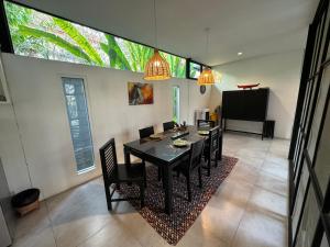 a dining room with a black table and chairs at Ren pool villa 清迈3卧泳池别墅 in Chiang Mai