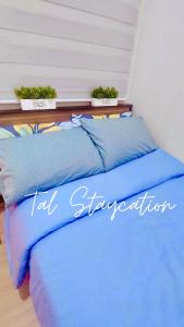 un letto blu con due piante sopra di TAL Staycation 1 Bedroom 1 Bathroom & Kitchen ,Neflix,up to 300 to 400 mbps high speed internet cozy,spacious,accessible new condo unit at SMDC Trees Residence Quezon City a Manila