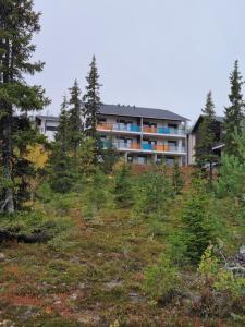 an apartment building on top of a hill with trees at Laskijantie10C in Ylläs