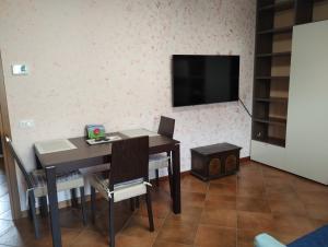 a dining room with a table and a flat screen tv at Border House in Gorizia