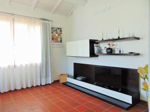 sala de estar con TV grande y ventana en Appartamento Giglio Rosso, en Scarperia
