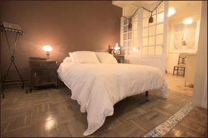 a bedroom with a bed with white sheets and a lamp at Tolosa un mundo de sensaciones in Tolosa
