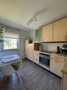 a kitchen with a table and a stove top oven at Loh Apartments - Wald.Natur.Ruhe. in Undeloh