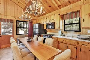 2464-Bruin Chalet cabin في بيغ بير لاكي: مطبخ مع طاولة وكراسي خشبية