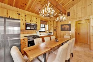 2464-Bruin Chalet cabin في بيغ بير لاكي: مطبخ مع طاولة وكراسي خشبية طويلة