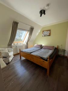 Schlafzimmer mit einem Bett und einem Fenster in der Unterkunft Loh Apartments - Wald.Natur.Ruhe. in Undeloh