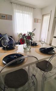 a dining room table with plates and wine glasses at Appartamento Nadia, bilocale nel verde a 5 minuti dal centro in Merano