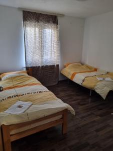 twee bedden in een kamer met houten vloeren bij BIANCA LuX in Kraljevo