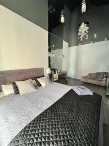 1 dormitorio con 1 cama grande y 1 sofá en EVIS LTD apartments 1, en Rēzekne