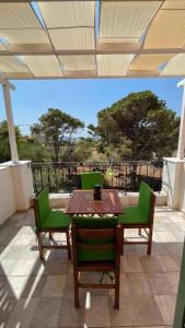 eine Terrasse mit einem Tisch und Stühlen auf dem Balkon in der Unterkunft SMAG Suites in Agios Petros