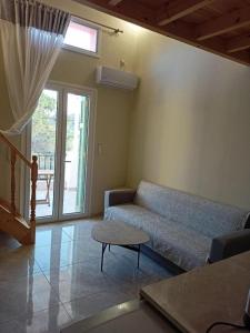 a living room with a couch and a window at SMAG Suites in Agios Petros