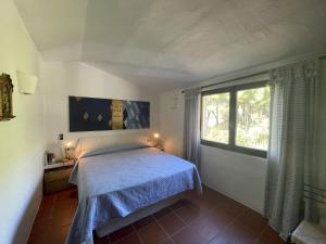 1 dormitorio con cama y ventana grande en VILLA FARFALLE CON STREPITOSA SCOGLIERA PRIVATA, en Capo Coda Cavallo