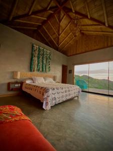 1 dormitorio con 2 camas y ventana grande en La Cabaña de Iza en Canoas