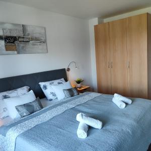 a bedroom with a blue bed with towels on it at Apartman Selska in Zagreb