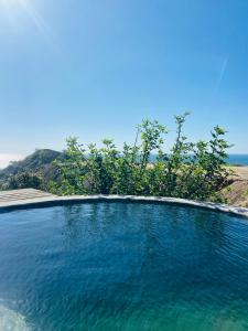 a pool of blue water with a view of the ocean at La Cabaña de Iza in Canoas