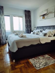 a bedroom with a large bed and two windows at Apartman Selska in Zagreb