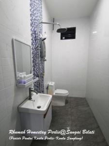 a bathroom with a sink and a toilet and a mirror at Rhumah Sungai Belati in Simpang Empat +31 photos
