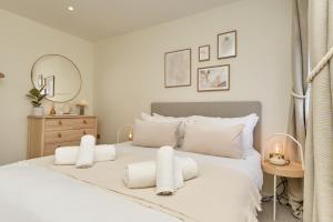 una camera da letto con un letto bianco con cuscini bianchi di West Cowes Penthouse a Cowes