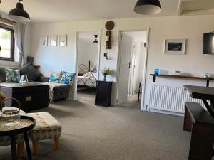 a living room with a couch and a table at Horseshoe Cottage in Looe