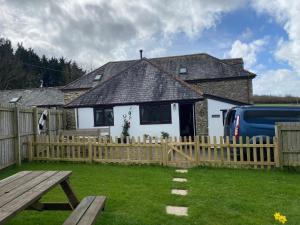 a house with a wooden fence and a picnic table at Horseshoe Cottage in Looe