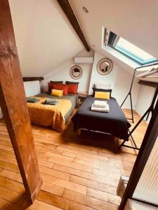 Schlafzimmer im Dachgeschoss mit 2 Betten und einem Fenster in der Unterkunft Maison avec spa proche paris in Saint-Denis