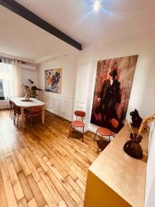 una sala de estar con una mesa y una pintura en la pared en Maison avec spa proche paris en Saint-Denis