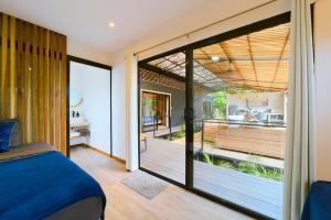 Schlafzimmer mit einem Bett und einer Glasschiebetür in der Unterkunft Al Caribe Sur in Puerto Viejo