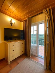 een woonkamer met een dressoir en een glazen schuifdeur bij Casa da Azenha in Lamego