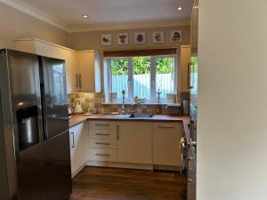 a kitchen with a stainless steel refrigerator and a window at The Annexe in Street