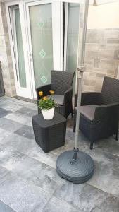 une terrasse couverte avec 2 chaises et une table avec un pot de fleurs dans l'établissement Casetta Nilu', à Procida
