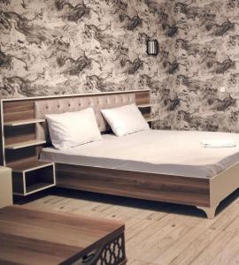 uma cama num quarto com uma parede em Al breeze em Baku