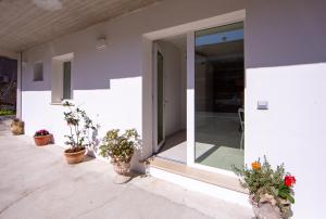 a white house with potted plants on the porch at Ars de mar in Martinsicuro