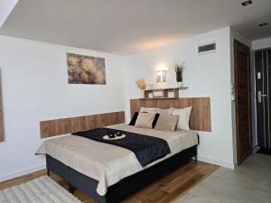 a bedroom with a large bed with a wooden headboard at nowe apartamenty nad Górskim Potokiem w Willi Sowiej rowerownia monitorowana in Stronie Śląskie