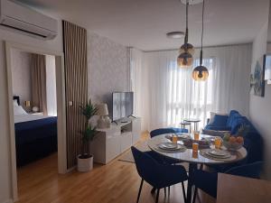 een woonkamer met een tafel en blauwe stoelen bij Salona Lux in Klis