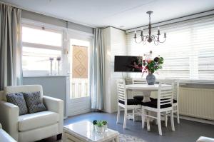 a living room with a table and chairs and a dining room at La Mare in Zoutelande