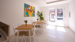a dining room with two tables and chairs and a painting at Ars de mar in Martinsicuro +52 photos