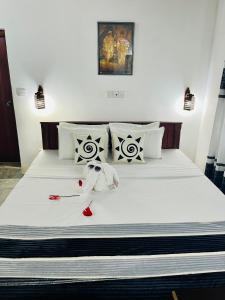 a bed with white sheets and white pillows at Villa Roy Bentota in Bentota