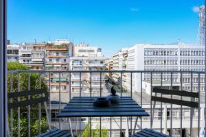 Una mesa en un balcón con vista a una ciudad. en Thessaloniki Center Downtown Apartment, en Tesalónica